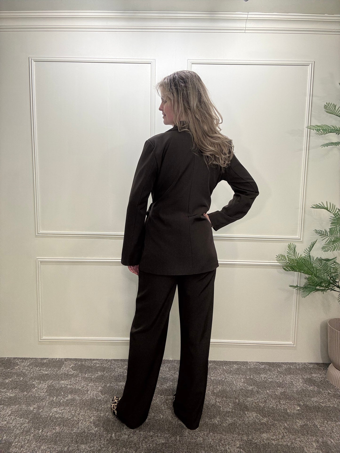 Set met een blazer met gouden gesp en pantalon in het bruin.